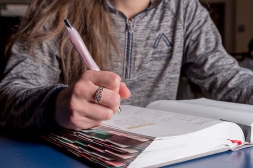 female student notating in her textbook